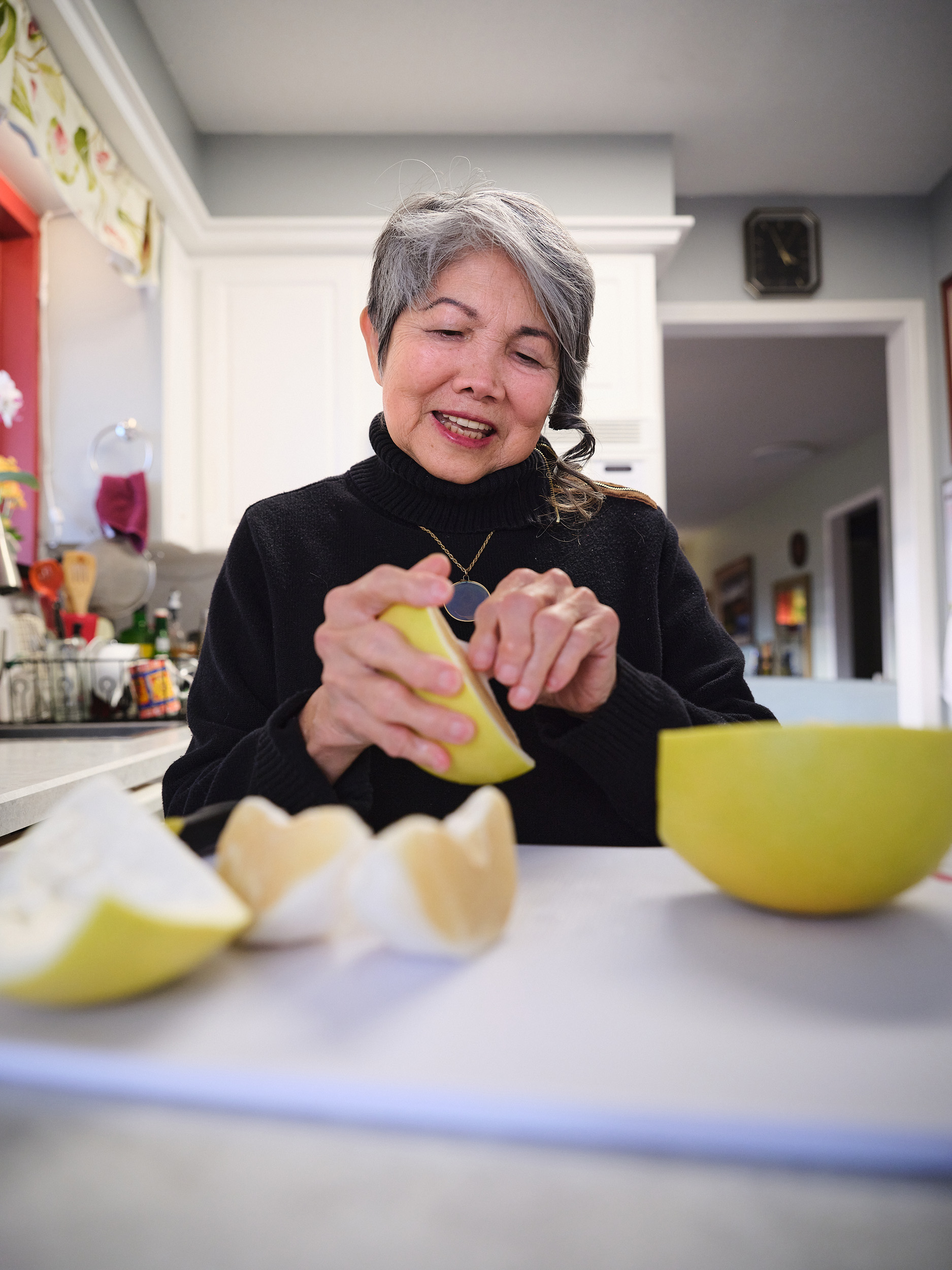 Arabella peeling pomelos in her kitchen.