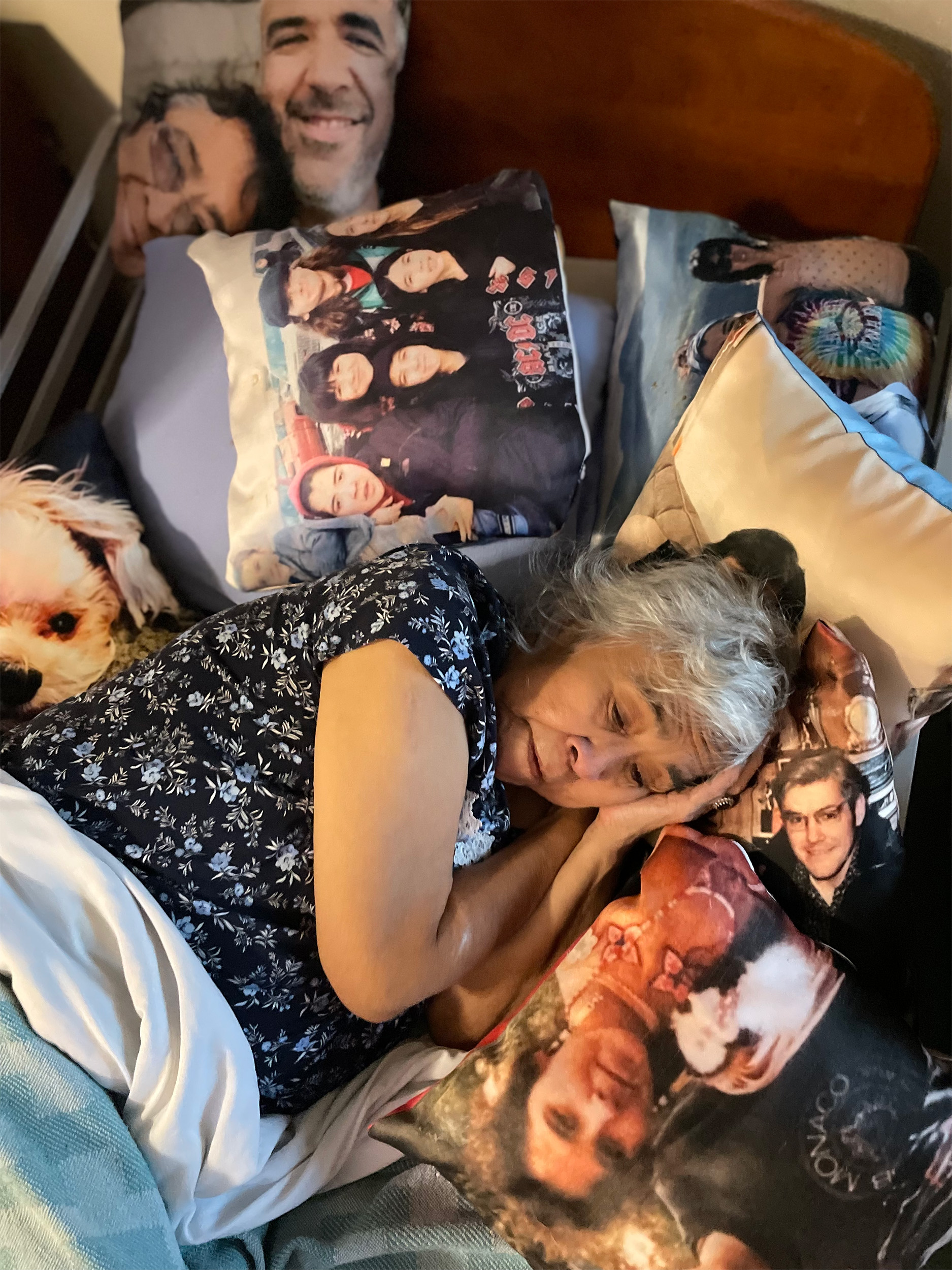 Janell resting on pillows with images of her family