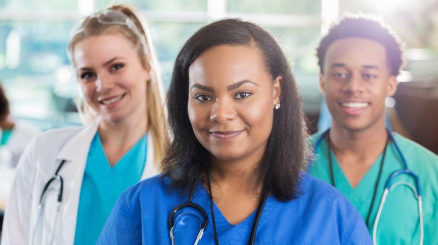 Three people wearing medical smocks