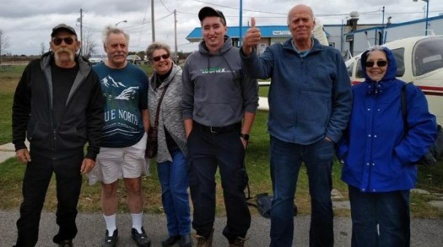 Five older adults and a tour guide at the Lindsay airport.